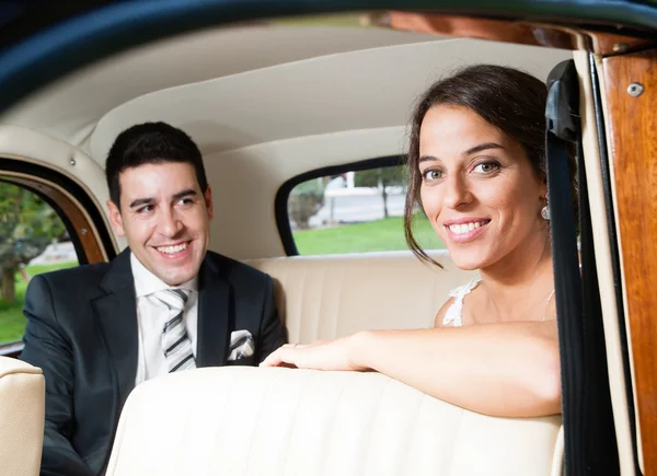 Жених и невеста в красивом классическом автомобиле — стоковое фото