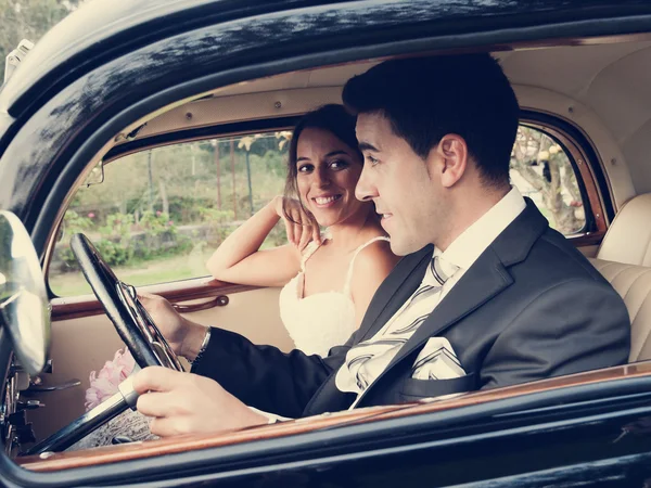 Bride and groom inside a classic car, vintage tone — Stock Photo, Image