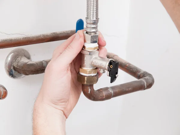 Homem reparando uma válvula de segurança de uma caldeira elétrica — Fotografia de Stock