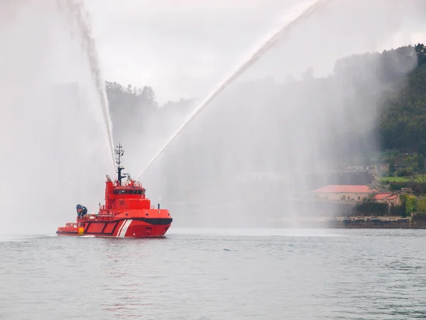 Salvage tugboat with two big water jets. — Stock Photo, Image