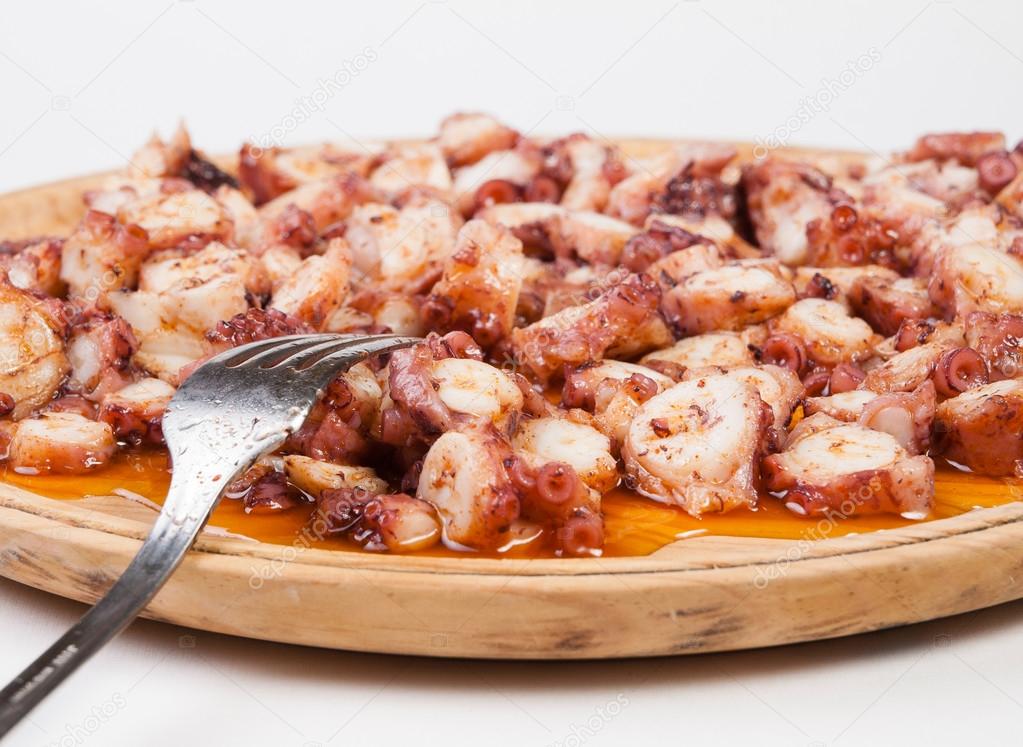 Pulpo a feira in a wooden plate with fork