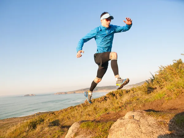 L'uomo pratica il trail running in un paesaggio costiero — Foto Stock