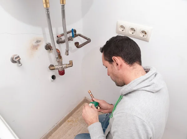 Plumber repairing an electric boiler — Stock Photo, Image