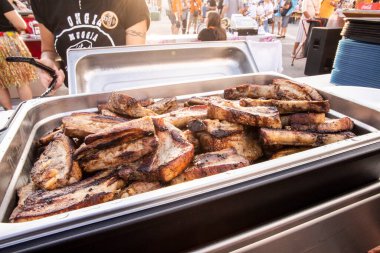 grilled pork ribs in a container, Muggia summer carnival fair, Trieste, Italy