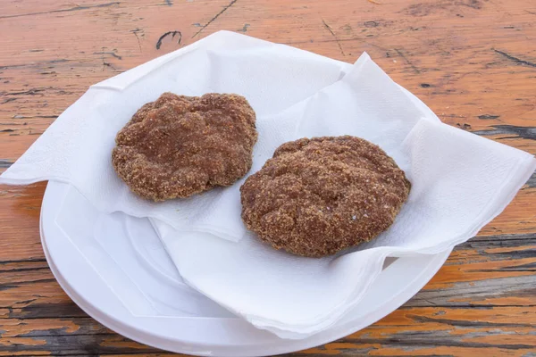 Fried meatballs on a plastic plate at the fair in Muggia, Summer Carnival, Italy