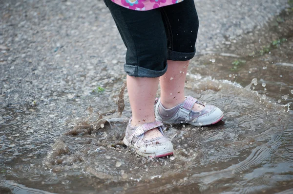 Peuter benen in regen plas golven — Stockfoto