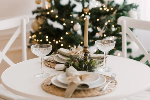 クリスマスツリーとお祝いのテーブル付きのリビングルームのスタイリッシュな明るいインテリア — ストック写真