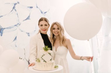 Açık arkaplanda pastası olan iki güzel sarışın kız.