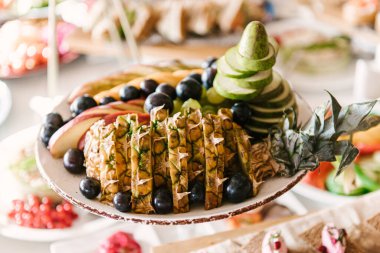 Güzel dekore edilmiş yemek sofrası farklı atıştırmalıklar ve sandviçli aperatifler şirket partisinde taze meyveler ya da düğün kutlamaları.