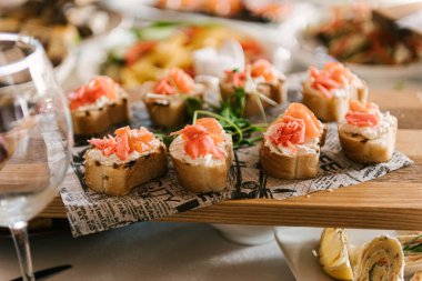 Güzel dekore edilmiş yemek sofrası farklı atıştırmalıklar ve sandviçli aperatifler şirket partisinde taze meyveler ya da düğün kutlamaları.