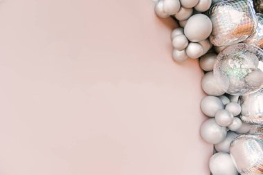 Metnini kopyalamak için boşluğu olan gümüş balonlardan oluşan yuvarlak pembe fotoğraf bölgesi. Parti balonlarla süslenmiş.