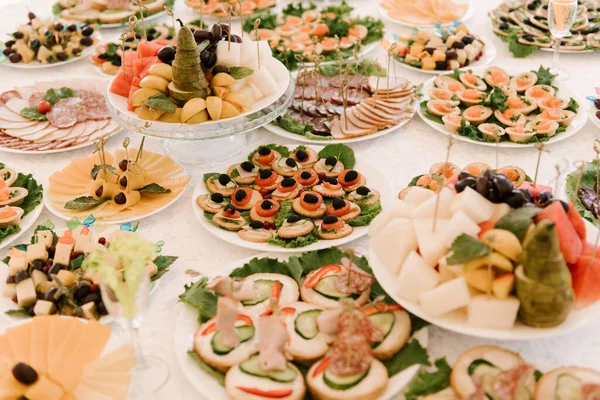 装饰精美的餐饮宴会桌与不同食品小吃和三明治 鱼子酱 新鲜水果公司方事件或婚礼庆典上的开胃菜 — 图库照片
