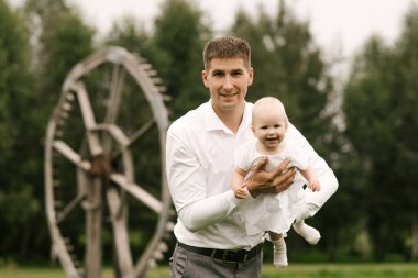 Güzel, genç bir aile, baba doğada bir yaşındaki kızıyla oynuyor.