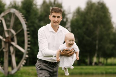 Güzel, genç bir aile, baba doğada bir yaşındaki kızıyla oynuyor.