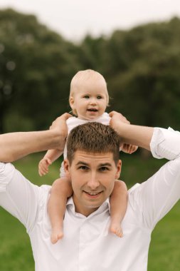 Güzel, genç bir aile, baba doğada bir yaşındaki kızıyla oynuyor.