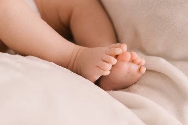 Hafif arka planda yeni doğmuş bir kızın küçük bacakları
