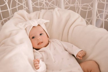 Beyaz elbiseli, beyaz arka planda tatlı yeni doğmuş kız.