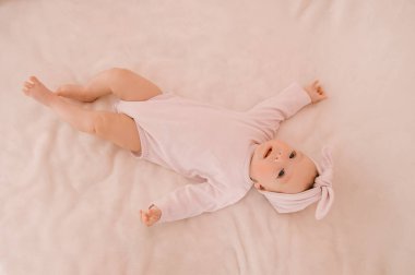 Hafif arka planda gülümseyen sevimli yeni doğmuş kız.