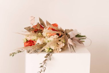 Saksıda güzel bir çiçek aranjmanı ve arka planda bir buket