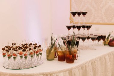 Bardaklarda atıştırmalıklar, sıcak kokteyller ve şarapla güzel ve lezzetli bir açık büfe.