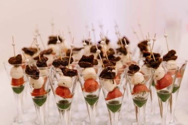 Güzel ve lezzetli bir açık büfe, bardakta domatesli ve peynirli atıştırmalıklar.