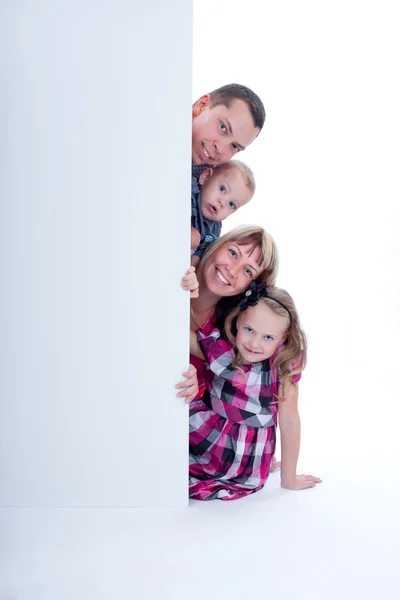 Sorridente famiglia sbirciare fuori Fotografia Stock