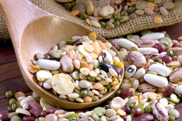 Mistura de legumes em uma colher de madeira — Fotografia de Stock