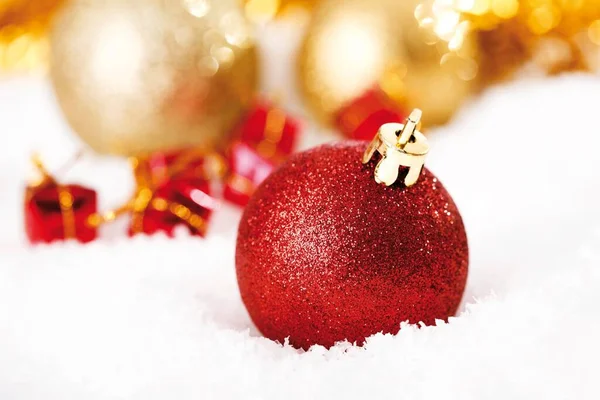 Rote Glitzernde Christbaumkugel Auf Schnee Mit Weihnachtsschmuck — Stockfoto