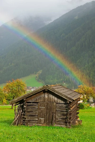 Rainbow above a wooden hut in Stubai Valley, Tyrol, Austria, Europe