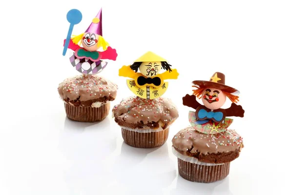Chocolate-coated muffins with decorative paper figurines