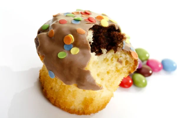 Muffin with smarties on white background