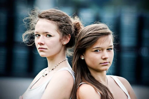 Two Teenage Girls Standing Back Back Looking Serious — Zdjęcie stockowe