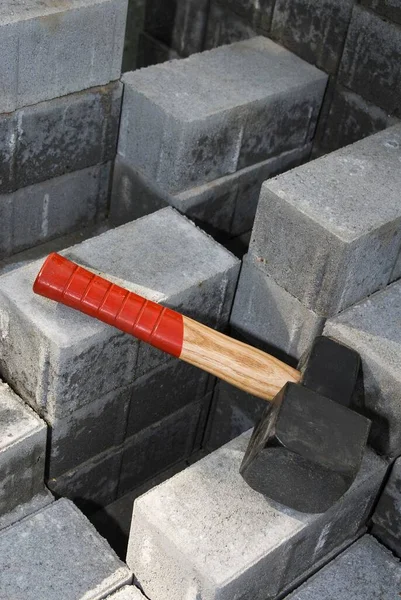 End of the work day, a hammer lying on a pallet of paving blocks