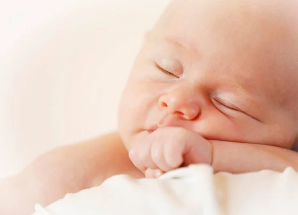 Baby girl, 3 months, being held by her mother, sleeping, portrait