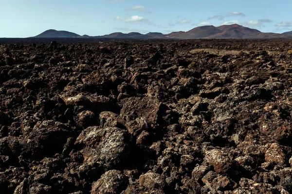 Lava field, volcanic landscape, Fire Mountains at the back, volcanoes, Timanfaya National Park, Lanzarote, Canary Islands, Spain, Europe
