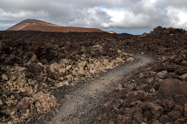 Path through a lava field, volcanic landscape, Fire Mountains, volcanoes, Caldera Blanca volcano at the back, Lanzarote, Canary Islands, Spain, Europe