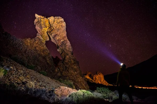 Man with headlamp, flashlight, standing in front of Zapato de la Reina, Queen\'s shoe, rock formation, night scene with stars sky, Las Caadas, Teide National Park, Tenerife, Canary Islands, Spain, Europe