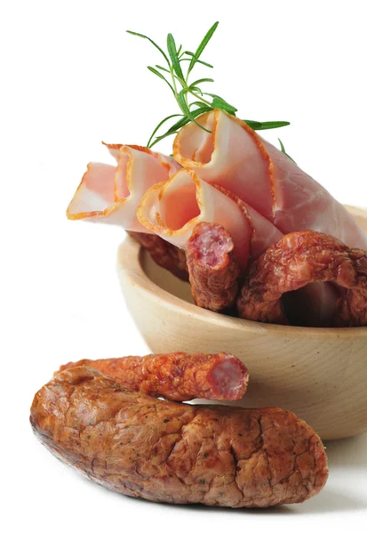 Saucisses de viande et jambon dans un bol en bois sur fond blanc — Photo