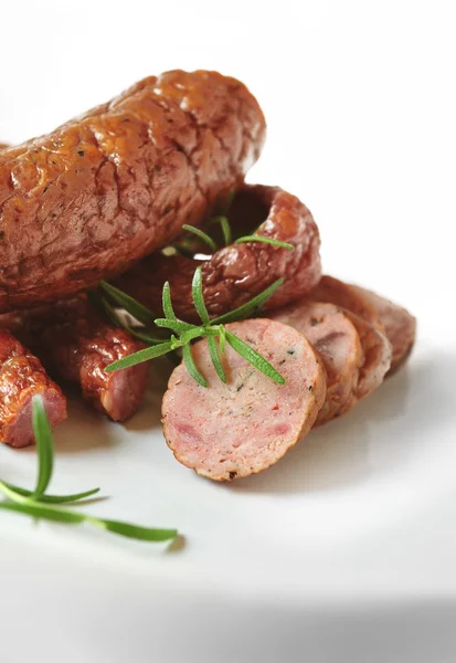 Embutidos de carne sobre fondo blanco con hierbas y especias — Foto de Stock