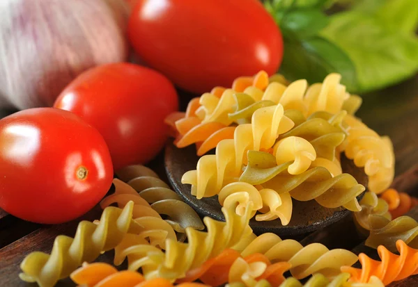 Italian raw pasta with garlic and cherry tomatoes — Stock Photo, Image