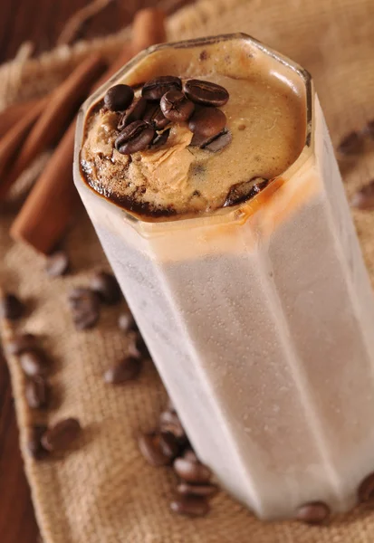 Cold fresh ice coffee with coffee beans and cinnamon - close up — Stock Photo, Image