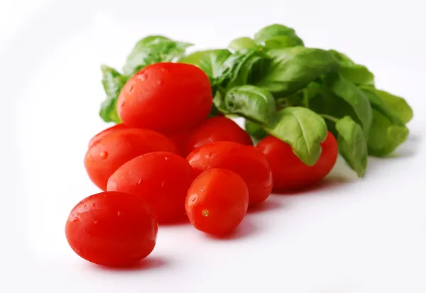 Świeży mokry pomidory z bazylią liść na białym tle — Zdjęcie stockowe