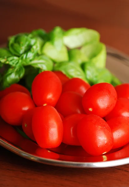 Fresh wet cherry tomatoes with basil — Stock Photo, Image