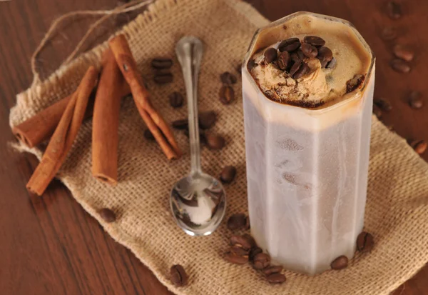 Cold fresh ice coffee with coffee beans and cinnamon - close up — Stock Photo, Image