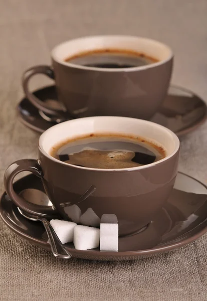 Due tazze di caffè marrone con cubetti di zucchero — Foto Stock
