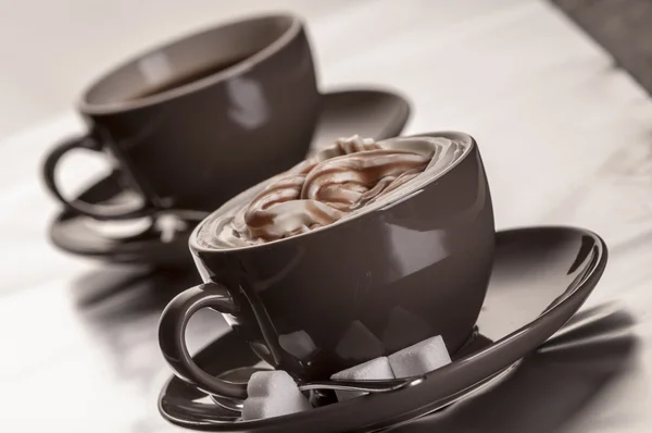 Zwei braune Kaffeetassen mit Zuckerwürfeln — Stockfoto