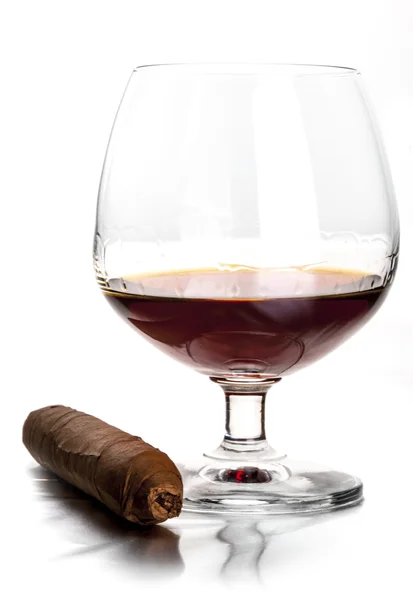 Glas cognac en een sigaar op de witte achtergrond — Stockfoto