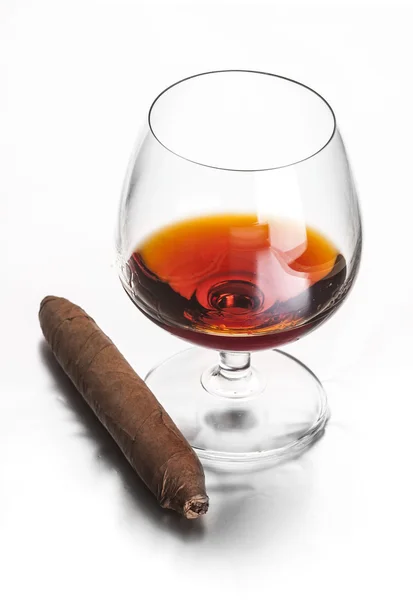 Verre de cognac et cigare sur fond blanc — Photo