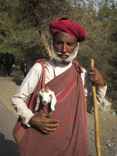 Old sheperd carrying a lamb. — Stock Photo, Image