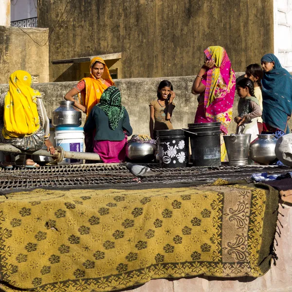 Indiase vrouwen praten naast een goed. — Stockfoto